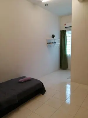 a bedroom with a bed in the corner of a room at Dudu Guesthouse Kuala Kangsar in Kuala Kangsar