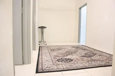 a rug on a floor next to a door with a carpet at Dudu Guesthouse Kuala Kangsar in Kuala Kangsar