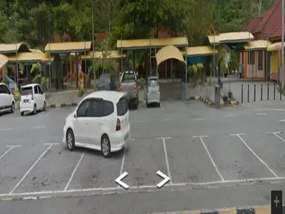a white car parked in a parking lot at GERIK BANDING HOMESTAY in Gerik