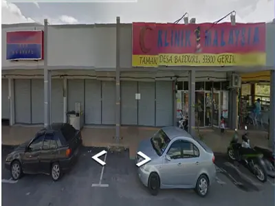 two cars parked in a parking lot in front of a store at GERIK BANDING HOMESTAY in Gerik