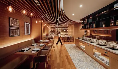 a dining room with a person walking in the distance at Victoria Garden Hotel in George Town