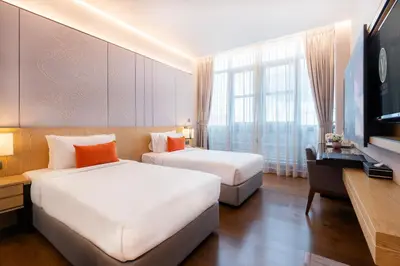 a hotel room with two beds and a flat screen tv at Victoria Garden Hotel in George Town