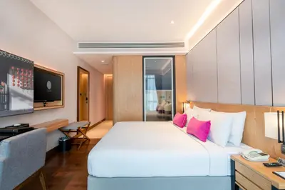 a hotel room with a large bed and a television at Victoria Garden Hotel in George Town