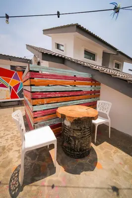 a table and chairs on a patio with a wooden wall at The Best Hotel in Bayan Lepas - THE LOV PENANG in Bayan Lepas