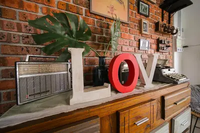 a brick wall with a love sign on top of a dresser at The Best Hotel in Bayan Lepas - THE LOV PENANG in Bayan Lepas