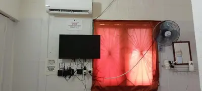 a room with a red curtain and a fan at JSW Inn in Gelugor
