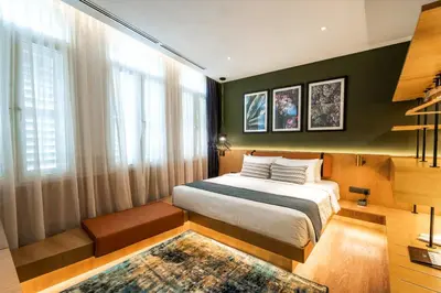 a bedroom with a bed and a large window at Macalister Hotel Managed by The Ascott Limited in George Town