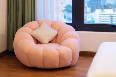 a peach chair with a pillow in a room at Tropicana 218 Macalister X Airlevate Suites in George Town