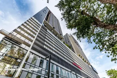 a tall building with glass windows at Tropicana 218 Macalister X Airlevate Suites in George Town