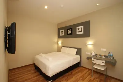 a bedroom with a bed and a desk with a phone at Ipoh Boutique Hotel in Ipoh