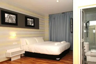 a bedroom with a white bed and a bathroom at Ipoh Boutique Hotel in Ipoh