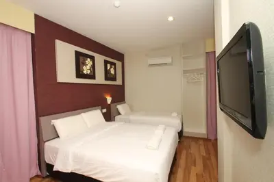 a bedroom with two beds and a flat screen tv at Ipoh Boutique Hotel in Ipoh