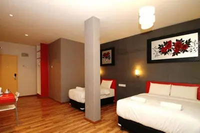 a hotel room with two beds and a table and a room at Ipoh Boutique Hotel in Ipoh