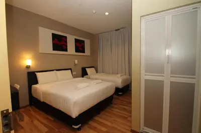 a hotel room with two beds and a closet at Ipoh Boutique Hotel in Ipoh