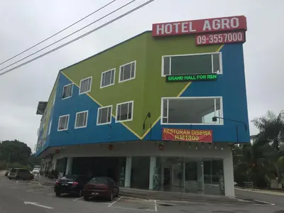 a hotel area with cars parked in a parking lot at Hotel Agro in Raub