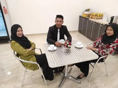 a man and two women sitting at a table at Hotel Agro in Raub
