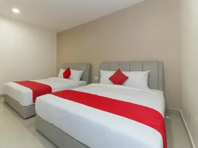 two beds with red pillows in a bedroom at Hotel Agro in Raub