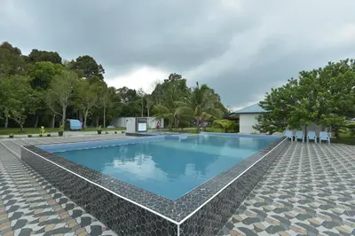 a swimming pool with blue water in a resort at AsiaCamp - Chalet Sungai Sireh in Tanjung Karang