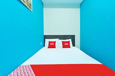 a bedroom with a bed with red and blue at Hotel O Bamboo Inn in Batu Ferringhi