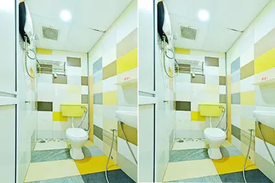 a bathroom with two toilets and two sinks at Hotel O Bamboo Inn in Batu Ferringhi
