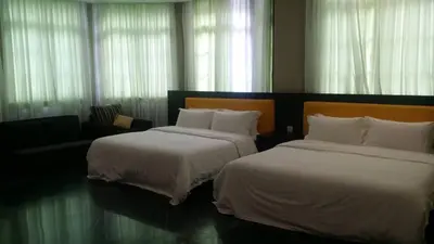 a hotel room with two beds and a couch at 6, Persiaran Tanjung Bunga 3 in Batu Ferringhi