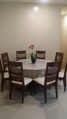 a dining room table with a vase on top of it at 6, Persiaran Tanjung Bunga 3 in Batu Ferringhi