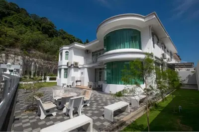 a large white building with a table and chairs at 6, Persiaran Tanjung Bunga 3 in Batu Ferringhi
