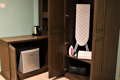 a kitchen with a cupboard with a microwave and a television at The Tudor in Ipoh