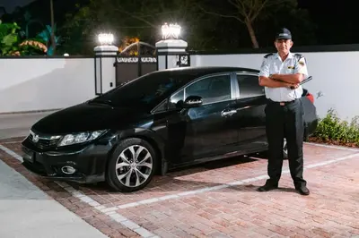 a police officer standing in front of a car at The Tudor in Ipoh