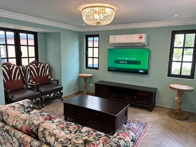 a living room with a couch and a flat screen tv at The Tudor in Ipoh