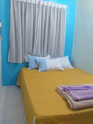 a bedroom with a large bed with a window at AsSalam Homestay in Seri Iskandar
