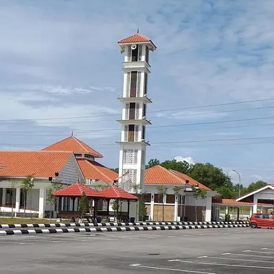 a building with a clock tower in the middle of a street at AsSalam Homestay in Seri Iskandar