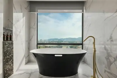 a bath tub in a bathroom with a window at The Millen Penang, Autograph Collection in George Town