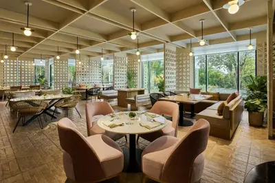 a restaurant with tables and chairs and windows at The Millen Penang, Autograph Collection in George Town