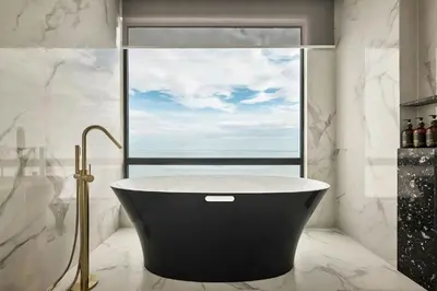 a bath tub in a bathroom with a window at The Millen Penang, Autograph Collection in George Town