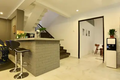 a living room with a bar and a staircase at G Beach Front Villa in Batu Ferringhi