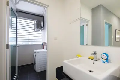 a bathroom with a white sink and a shower at Straits Garden Suites, Georgetown in George Town