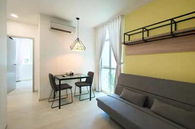 a living room with a bed and a table with chairs at Straits Garden Suites, Georgetown in George Town