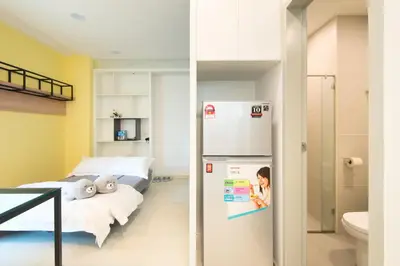 a room with a refrigerator next to a bed at Straits Garden Suites, Georgetown in George Town