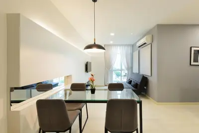 a living room with a glass table and chairs at Straits Garden Suites, Georgetown in George Town