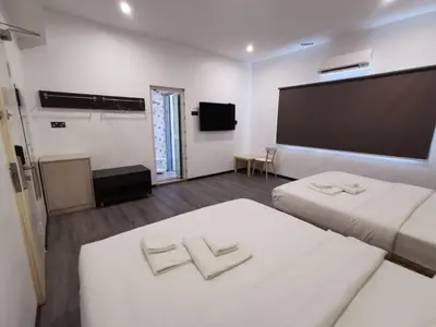 a hotel room with two beds and a large screen at TT Dorf Hotel Matang in Taiping