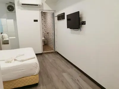 a room with a bed and a tv on a wall at TT Dorf Hotel Matang in Taiping