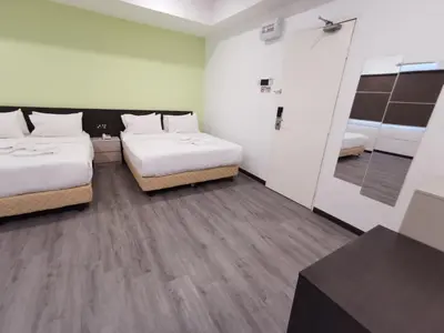a hotel room with two beds and a mirror at TT Dorf Hotel Matang in Taiping
