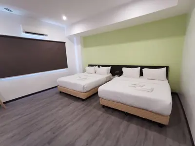 a room with two beds and a flat screen tv at TT Dorf Hotel Matang in Taiping