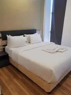 a large bed with white sheets and white pillows at TT Dorf Hotel Matang in Taiping