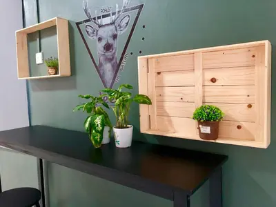 a desk with plants and a cabinet with a deer on the wall at The Alley's @ Sitiawan, Manjung in Sitiawan