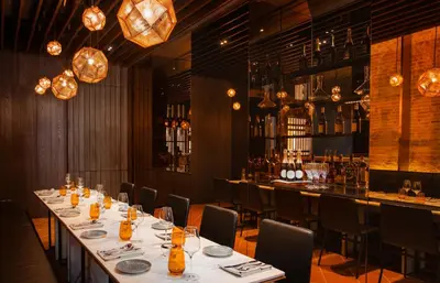 a dining room with a long table and a bar at 88 Armenian in George Town