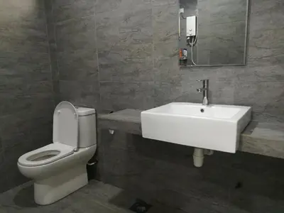 a bathroom with a white sink and a toilet at Mevin Woodsbury Butterworth Homestay in Butterworth