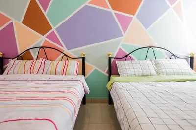 two beds in a room with a colorful wall at ICOLOR HOME & STAY CH1 in Tanah Rata