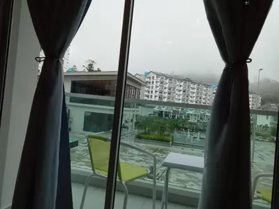 a view of a city from a window with curtains at ICOLOR HOME & STAY CH1 in Tanah Rata